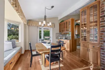 The dining room caters effortlessly to both formal dinners and casual meals, featuring a warm ambiance, built-in window seating, elegant glass-front cabinetry, and an unbelievable mountain view.