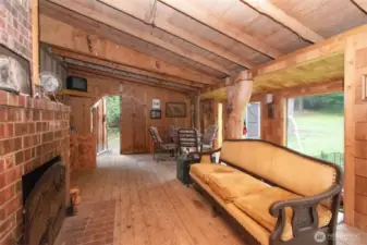 Enclosed back porch with wood burning fireplace.