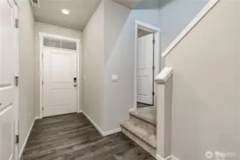 Main entry - door to the garage on the left, half bath on the right