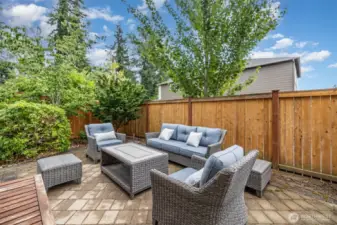 Large back patio surrounded by easy-care trees and shrubs is perfect for relaxing on summer evenings!