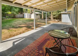 The covered back patio is the ideal space to host gatherings through all of the seasons. Check out all of those awesome outbuildings waiting on your gardening tools and yard games!