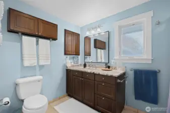 Spacious bathroom with jetted tub, heated floors, ample storage, and natural light