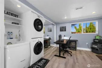 Modern laundry area with stacked washer/dryer and workspace all located in the extra bonus room