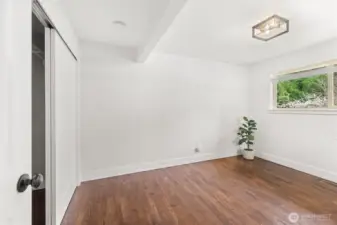 Primary Bedroom: Window, wood blinds, large closet.