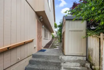 Side of home with access to lower level along with a shed