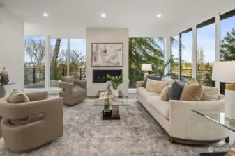 Living area with floor to ceiling windows and gas fireplace.