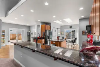 Look at all of the space for seating at this long kitchen counter with slab granite countertop.