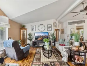Large family room with vaulted ceilings and engineered hardwood flooring.