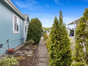 Paved side walkway with room for a garden and flowers.