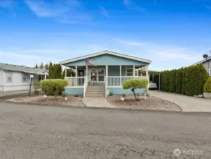 Beautiful Home with large covered front porch, private driveway, and carport.