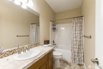 Hall/guest bath has counter space a an easy maintenance shower/bath.