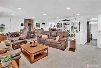 The free-standing stove adds warmth and coziness to the room, making it a perfect spot to relax. Two built-in safes offer extra security—one hidden behind the door to the left of the fireplace and the other cleverly concealed behind the picture to the right.