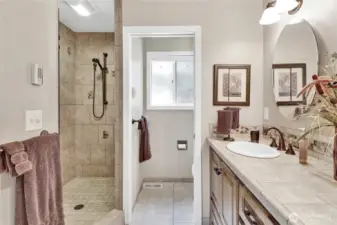 The primary bathroom features a large walk-in shower, radiant heated tile floors, and a double-sink vanity for both style and convenience.