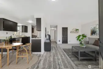 Virtual Staging-From Front Door.  LVP flooring throughout kitchen, dining, hallway, and primary bedroom. New carpet in living room and guest bedrooms.