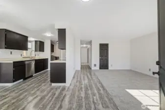 From Front Door.  LVP flooring throughout kitchen, dining, hallway, and primary bedroom. New carpet in living room and guest bedrooms.