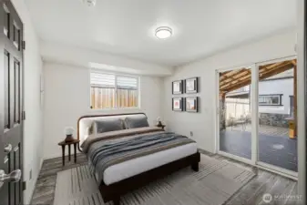 Virtual Staged-Primary bedroom with sliding glass doors leading to covered deck in backyard.