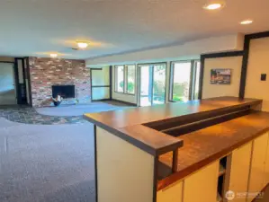 Lower level Family Room with wood burning fireplace. Bar area has power and water. Could be converted to a kitchen or entertainment bar with room for a pool table!