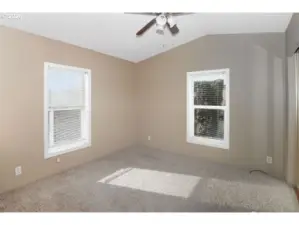 Primary bedroom with vaulted ceilings, ceiling fan, and oversized  closet space.