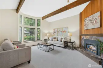 Floor-to-ceiling windows fill the living space with natural light and showcase the surrounding greenery.