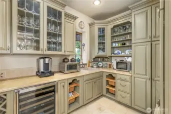 Butlers pantry off the kitchen with granite sink, notice ample storage with closed cabinets.