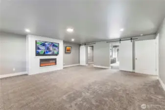Main level primary suite with electric fireplace and the tv conveys.