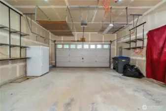 Oversized 2-car garage has custom overhead storage.
