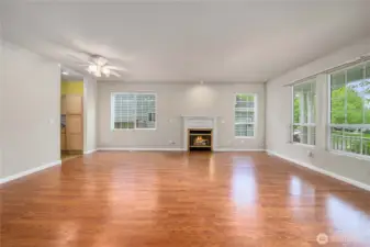 As you enter, this large living - dining area offers a gas fireplace and lots of windows to keep it bright. The covered front porch is on the right of this photo.