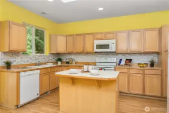 Custom backsplash will work with any color of paint. Center island has room for a couple of bar stools.