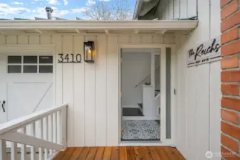 A welcoming covered front entry with plenty of space to arrive comfortably and to keep you and your guests protected from the rain while waiting to come inside. The new front deck creates a warm first impression, while the tall modern porch light  brings a warm glow onto the entry. Thoughtful exterior touches, modern black house numbers, and crisp board-and-batten siding, set the tone for the refreshed style throughout.