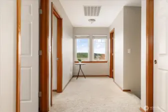 Heading upstairs, there is a wide hallway with natural  light.