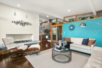 ...brick-faced gas fireplace with tiled hearth & custom steel firepan. And glass doors leading to the outdoor living space...