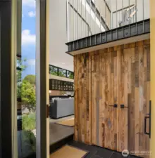 Upon entering the home you see the reclaimed wood accents & the steel staircase which add to the interesting use of textures...and the 12 foot ceilings which give this home the airy volume and light.