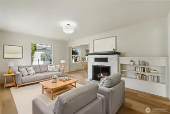 Virtually staged inviting living room featuring marble fireplace and built in bookcases