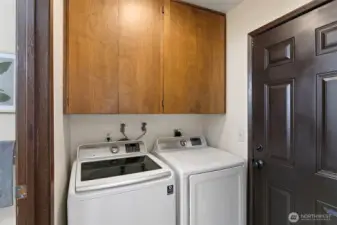 Tucked away by 9549 side door is a designated laundry space and utility cabinets.
