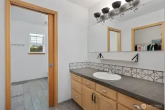 Pocket door separates the shower area and toilet from 2 vanities.