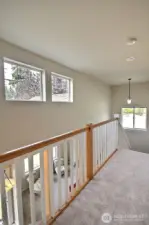 Love this impressive view from the landing on the upper floor showcasing the railing and more magnificent windows! The staircase features lighted stairs too!