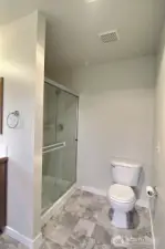 Oversized tiled shower and new flooring in the primary bathroom.