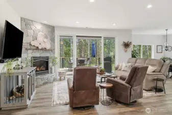 Wow!! The wall of glass doors invite you to take in nature and relax on the deck built with easy maintenance composite decking.  Two Gas Hookups... one for the BBQ and one for the Pizza Oven.  The deck run the full width on the home and the Primary Bedroom has access too.  The window coverings are on a remote for ease.  Solid Surface, Luxury Vinyl flooring thru-out the home! Heating/AC via the Electric Furnace & Efficient Heat Pump OR this beautiful gas fireplace !