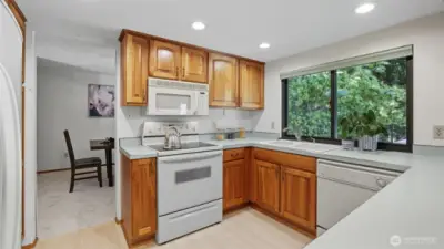 Enjoy a bright kitchen with ample cabinetry and a window overlooking lush greenery.