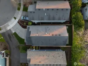 Aerial view showing the front yard, private driveway, and the fully fenced backyard.