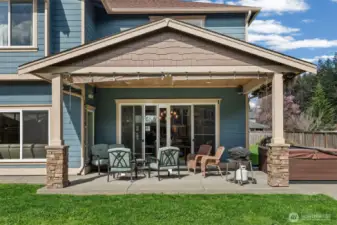 Covered outdoor living area with space for seating and year-round entertaining. Wired in speakers.