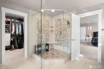 Luxury primary bath featuring a large walk-in shower, open layout, and walk in closet.