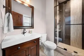 Additional bathroom with vanity storage and shower access.