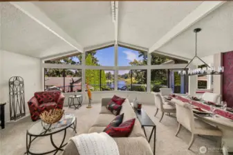 High vaulted ceilings accentuate the lake view in this spacious open concept living room and dining room.