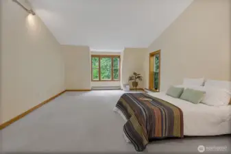 Retreat-style bedroom with abundant natural light and serene views.