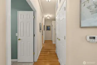 Bright hallway with hardwood floors and easy access to bedrooms and bath.