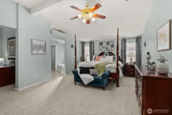 Spacious retreat with vaulted ceilings, soft natural light, and plush carpeting.