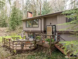 Front entry, stairs and deck. This looks out over what soon will burst forth in lush green leaves that bring beauty and privacy.