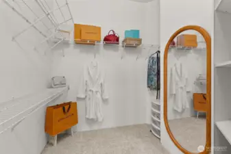 Generous walk-in closet with built-in shelving and space for every season.