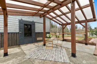 Covered back patio space sits between main house and large shed.